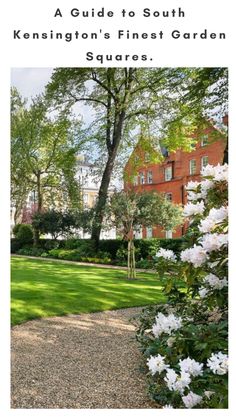 a garden with white flowers in the foreground and a red brick building in the background