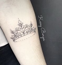 a small crown tattoo on the arm