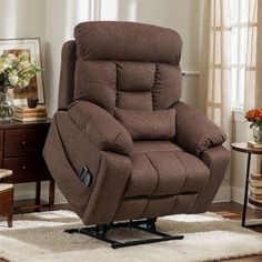 a brown recliner chair sitting on top of a rug in front of a window