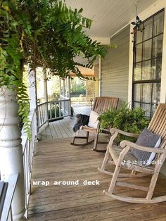 two rocking chairs on the front porch of a house with plants growing out of them