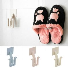 two pairs of slippers hanging on the wall next to hooks with clips in them