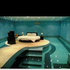 a bed sitting on top of a swimming pool next to a night stand and speakers