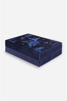 a black and blue box sitting on top of a white surface with an intricate design