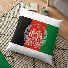 the flag of afghanistan is shown on a floor pillow, next to a coffee cup