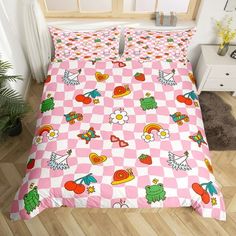 a bed with pink and white checkered bedspread, pillows and pillow cases