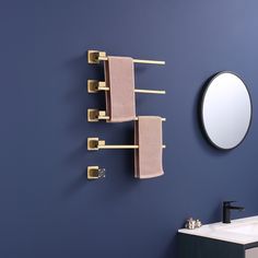 a bathroom with blue walls and gold towel racks