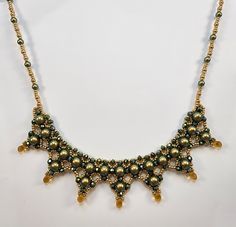 a necklace with gold and green beads