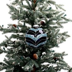 an ornament hanging from the top of a christmas tree with pine cones on it