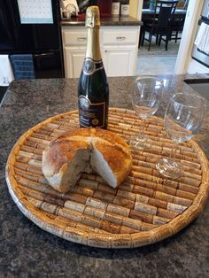 a bottle of wine sitting on top of a counter next to a plate with bread