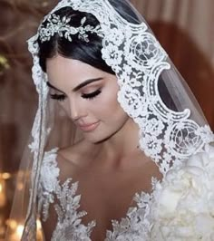 a woman wearing a wedding veil and holding a bouquet