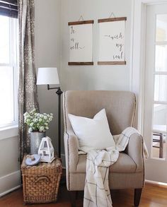 a living room with two framed pictures on the wall and a chair next to it