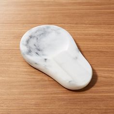 a white marble object sitting on top of a wooden table