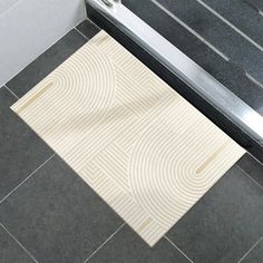 a white rug sitting on top of a bathroom floor next to a shower stall door