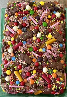 a green tray filled with lots of different types of candy and candies on top of it