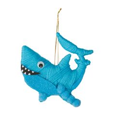 a blue ornament hanging from a string with a smiling shark on it's back