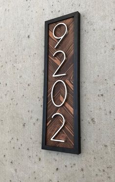 a wooden sign that says 2012 on the side of a wall with a black frame