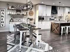 an open concept kitchen and dining room with white cabinets