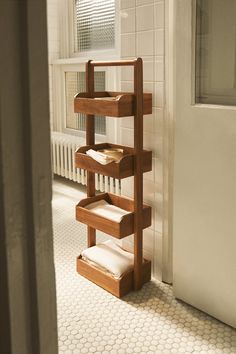 a wooden shelf sitting in the corner of a bathroom