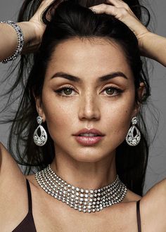 a beautiful woman in a black dress with pearls on her head