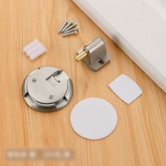 the contents of a door handle on a wooden floor with screws and other items