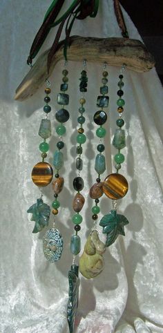 a close up of a necklace with beads and charms hanging from it's side