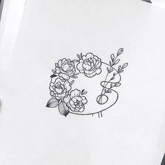 a pencil drawing of flowers on paper next to a pen and inking pad with the letter e