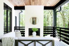 a white couch sitting on top of a wooden floor next to a fire place in a living room