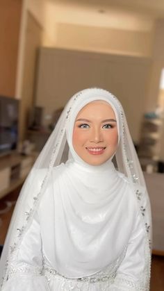 a woman wearing a white veil and dress