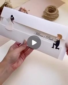 someone is holding up a wedding card with the bride and grooms name on it