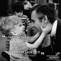 a man holding a little boy in his arms with the quote love is at the root of everything