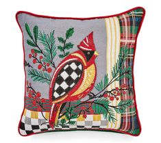 a decorative pillow with a red bird on it's back and plaid trimmings