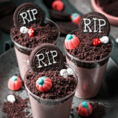 three cups filled with dirt and candy on top of a plate