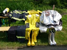 a fireman's gear is sitting on the grass next to a picnic table