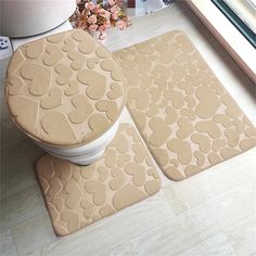 three bathroom mats with hearts on them in front of a window