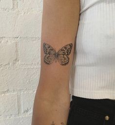 a woman's arm with a butterfly tattoo on the left side of her arm