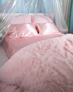 a bed with pink sheets and pillows in a room