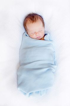 a newborn baby wrapped in a blue blanket