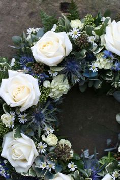 a wreath with white roses and greenery