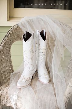 a pair of white cowboy boots sitting on top of a chair