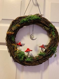 a wreath with mushrooms and moss hanging from the front door