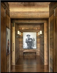 an empty room with wood paneling and pictures on the wall, along with wooden flooring