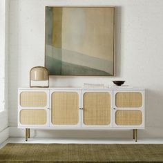 a white and beige sideboard in a room with a large painting on the wall