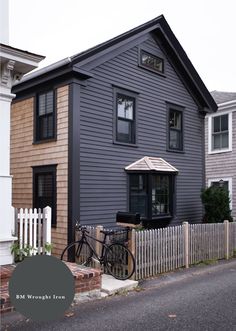 a bicycle is parked in front of a house with a picket fence around it's corner