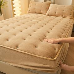 a person is touching the bottom of a mattress