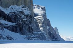 a person on skis is standing in the snow near a mountain side with snowy mountains