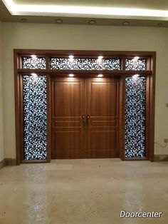 an empty room with two wooden doors and decorative glass panels