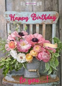 a happy birthday card with pink flowers in a bucket on top of an old chair