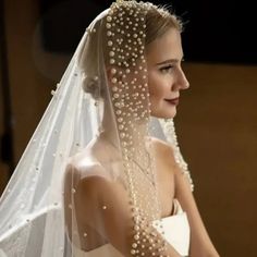 a woman wearing a veil with pearls on it