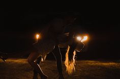 two people are dancing in the dark with their lights on