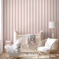 a baby's room with pink and white striped wallpaper, rocking chair and crib